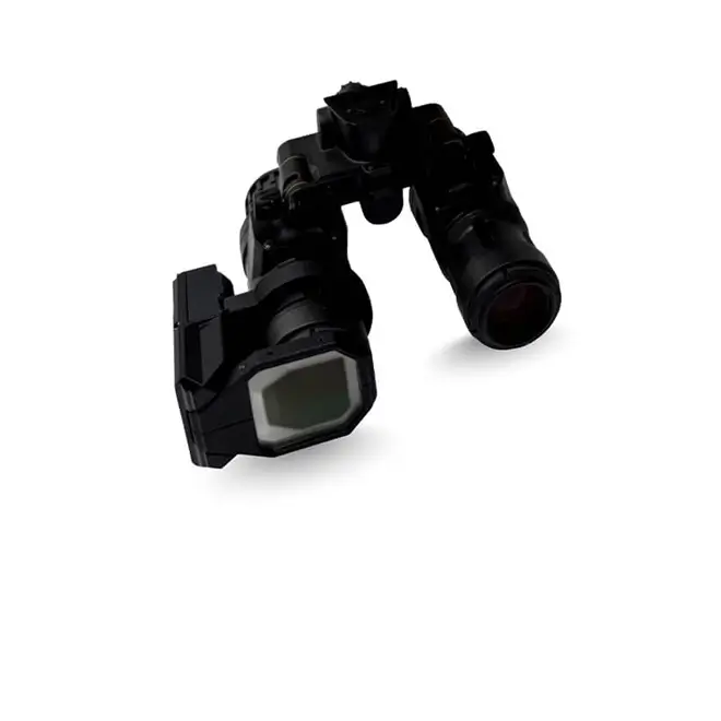 A pair of night vision goggles with a clip‑on augmented reality module attached to the front. The device has two cylindrical optical tubes connected by a central hinge, and a rectangular AR component mounted on one side with a reflective viewing surface. The equipment is shown isolated on a white background to represent Kopin’s DarkWAVE clip‑on AR system for night‑vision goggles.